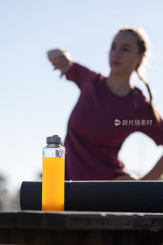 年轻女子在户外运动期间在外面补水。