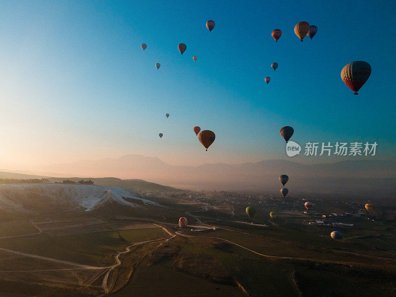 热气球飞过Pamukkale山谷，太阳从山上升起。无人机录像