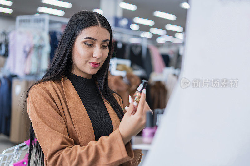 一个年轻漂亮的女人正在超市挑选衣服