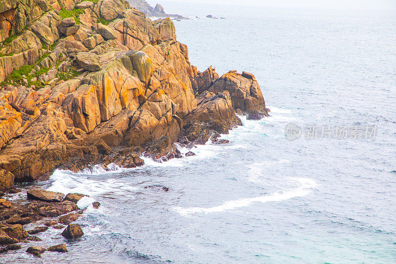 海浪在岩石悬崖上破碎的高角度视图