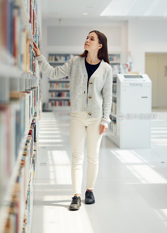 妇女，学生，在图书馆搜索图书选择，知识或在书店学习教育。女性在学习中看着书架作决定，思考或为奖学金选择论文