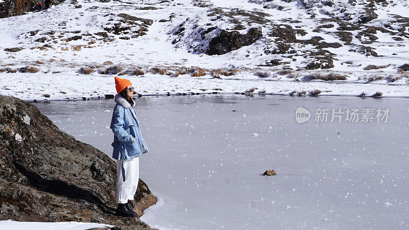 一个女人在寒冷的天气里穿行于白雪覆盖的山林之中