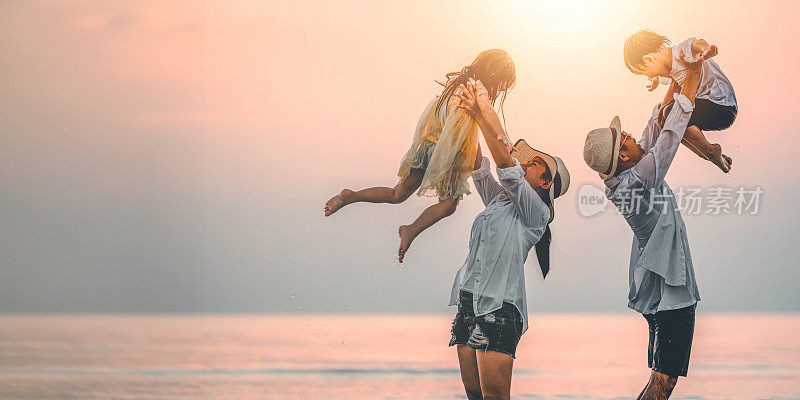 快乐的亚洲家庭在日落的海滩上玩海。全家人都喜欢带着孩子在海滩上玩耍。家庭、旅行、生活方式和假期。