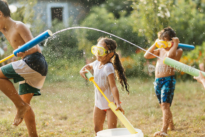 炎热的夏日，孩子们在院子里打水仗