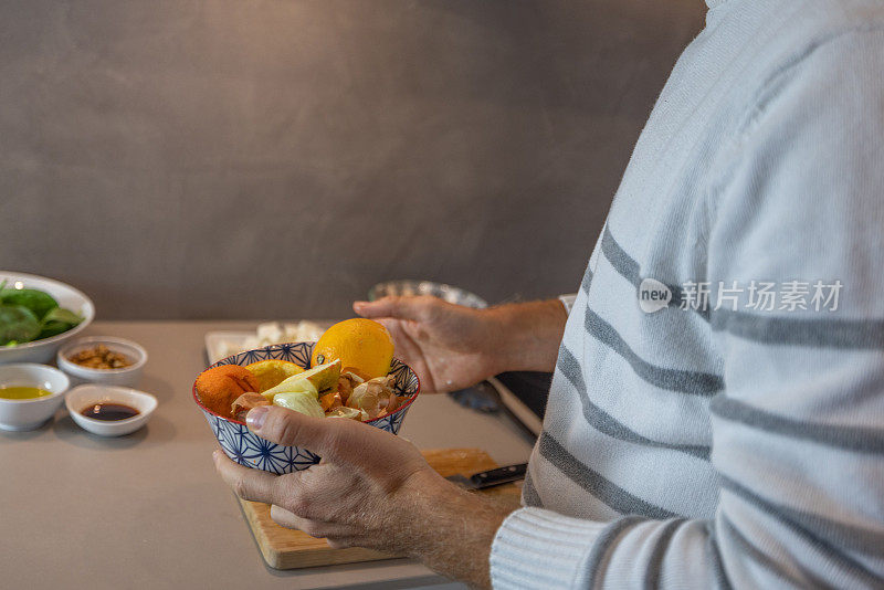 男子在自家厨房做饭，减少了家里的食物浪费