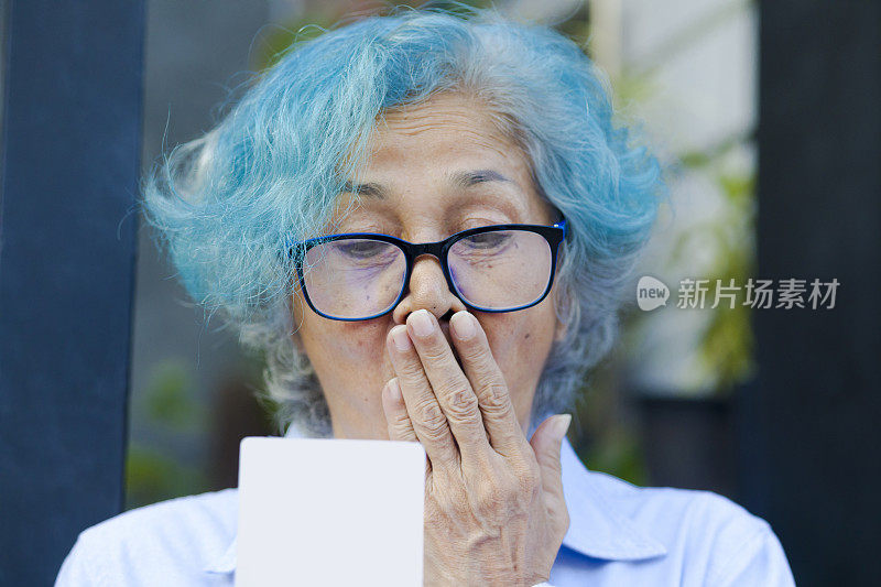 快乐的肖像惊讶的泰国老年妇女看着中奖彩票