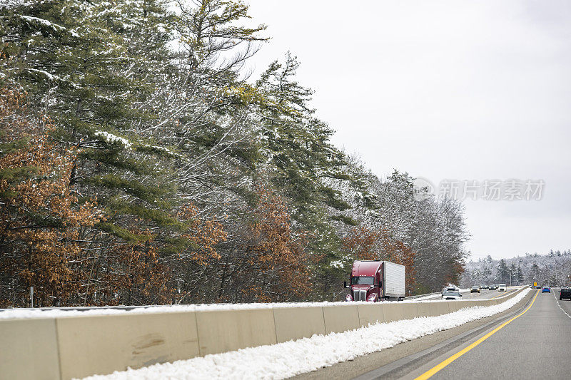 勃艮第大钻机长途半挂车运输货物在冰箱半挂车行驶在冬季公路上的雪和树木的两侧