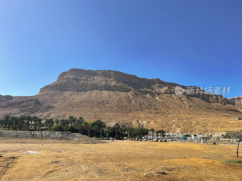 沙漠山景观:湛蓝天空下雄伟的山崖。这幅横向图像展示了在广阔的干旱环境中一个阳光明媚的日子