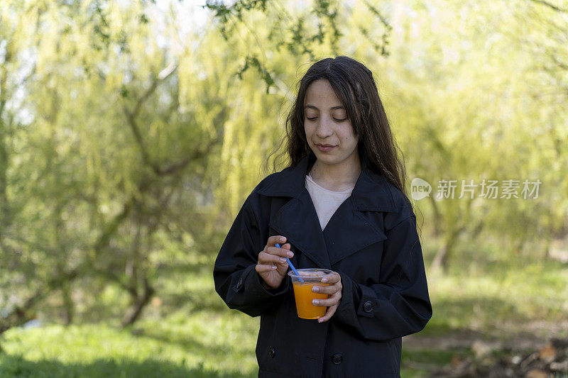 一个女孩在喝橙汁。