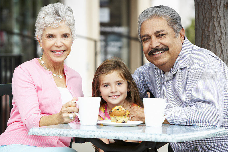 爷爷奶奶和孙女在户外咖啡厅享用小吃