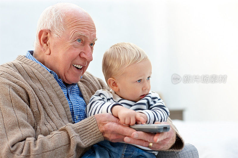 快乐的爷爷和孙子一起看电视