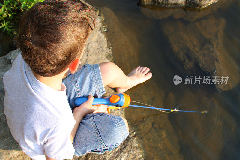 一个小男孩在水里钓鱼