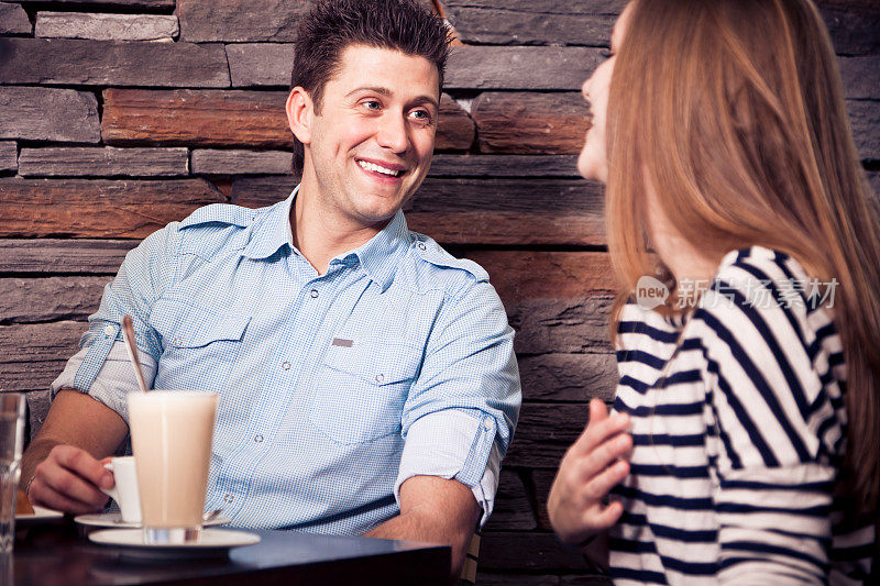 一对年轻夫妇坐在咖啡馆里