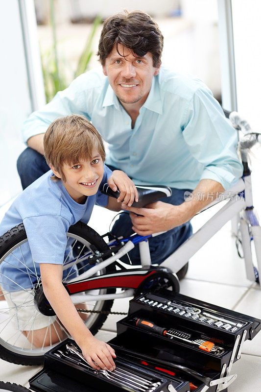 年轻的父亲和儿子一起修理自行车