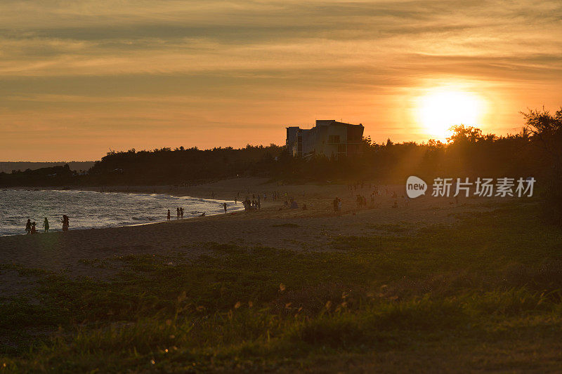 日落时人们在海滩上玩耍