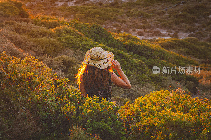 波西米亚女孩在夏日的阳光下漫步，享受大自然