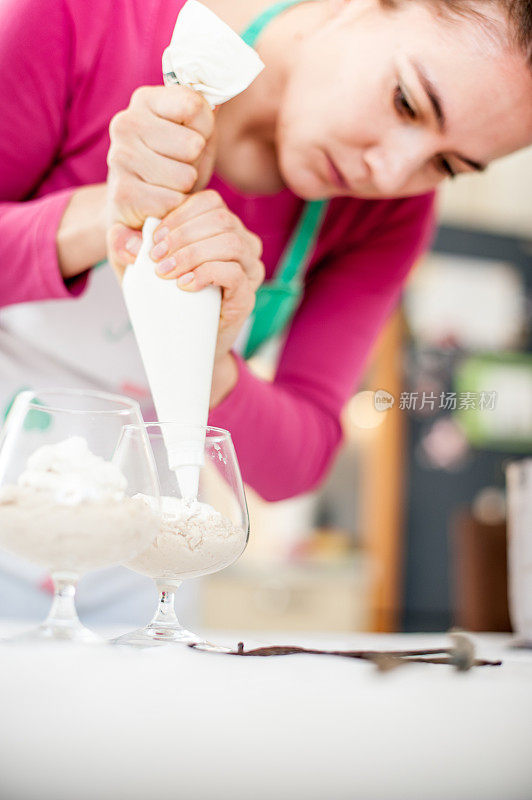 用杯子挤奶油的女人