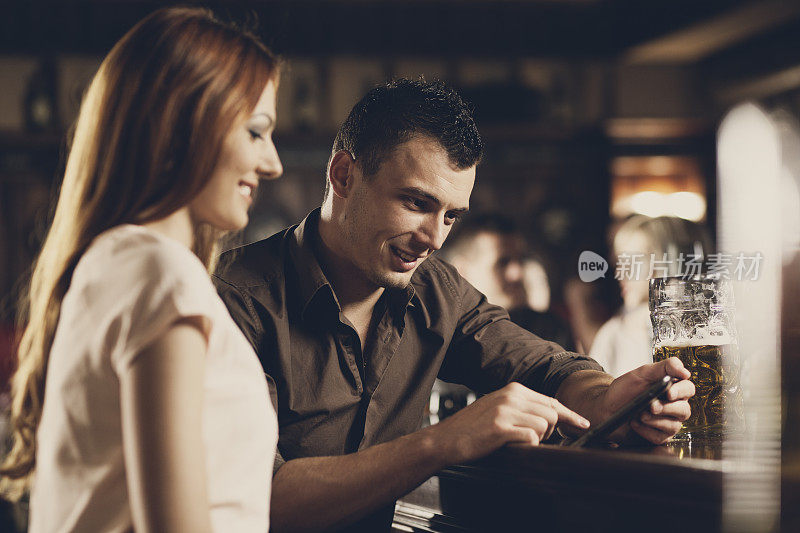 男人和女人在酒吧用平板电脑