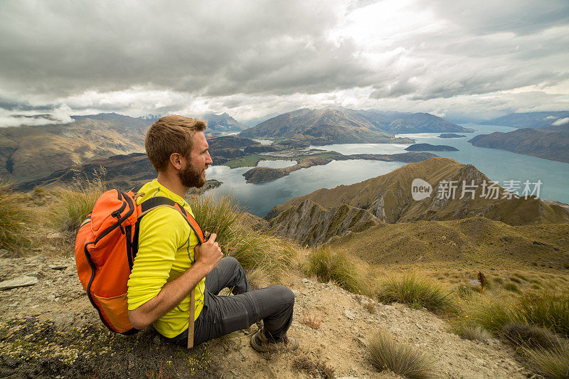 一个徒步旅行者坐在山顶上看风景