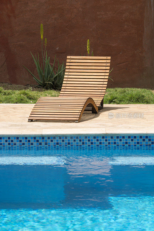 游泳池边的木制放松椅
