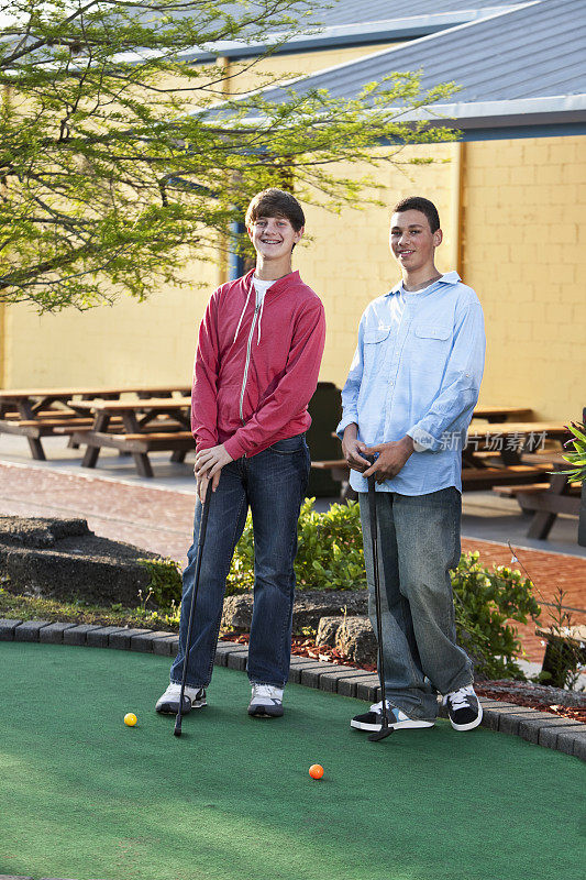 十几岁的男孩在打迷你高尔夫