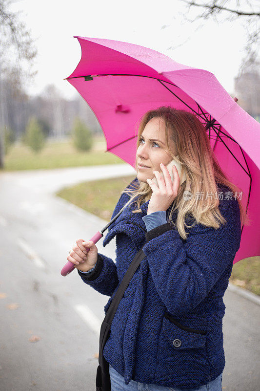 年轻女子与手机在雨天