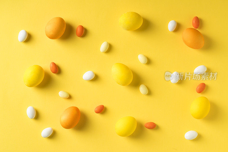 黄色彩蛋和彩色糖果在黄色的背景。