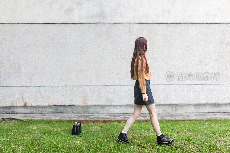 亚洲女孩独自走在墙上