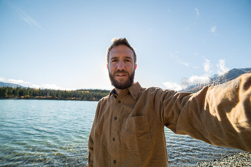 一名在加拿大旅游的快乐男子在湖边自拍