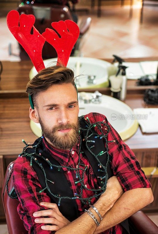 年轻的嬉皮士在理发店为圣诞节装饰