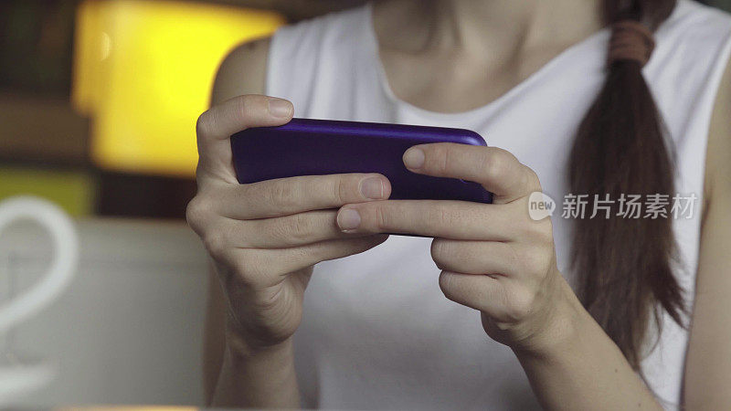 女人在智能手机上玩游戏的特写镜头
