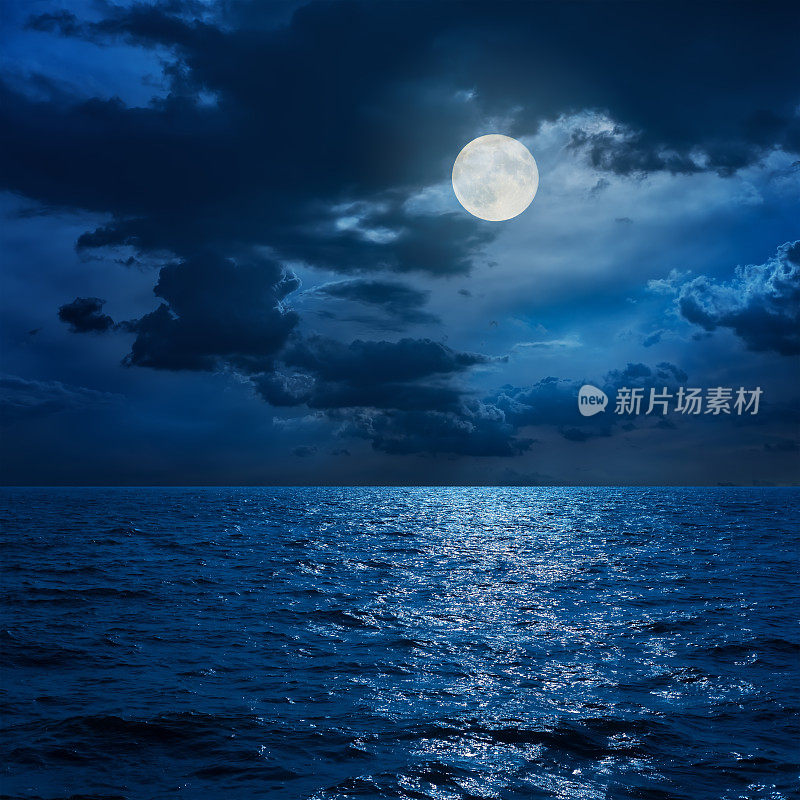 夜晚海上云中的满月