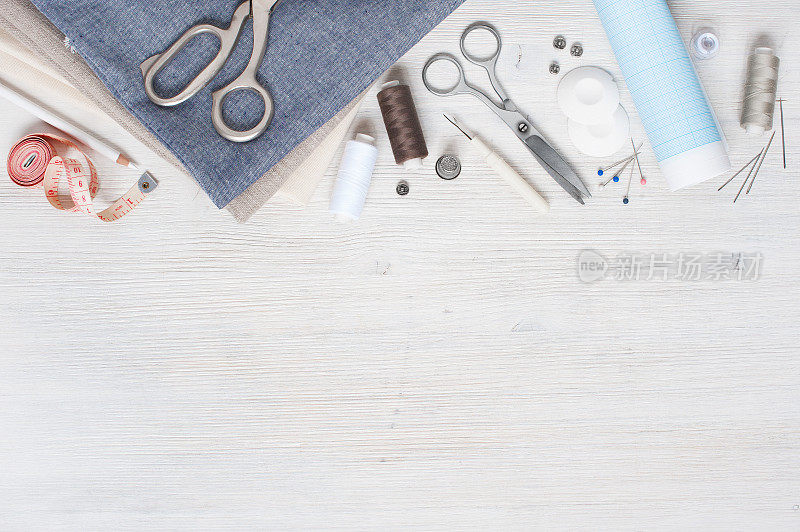 白色木桌上放着各种布料和缝纫工具