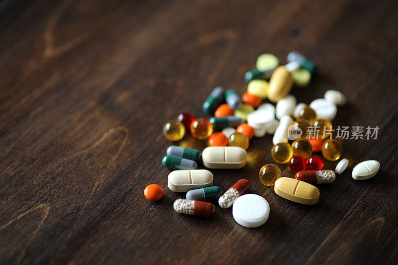 木纹桌子上放着药物和药片