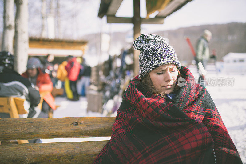 雪中年轻女子披着波西米亚风格的毯子和帽子