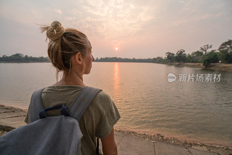 年轻女子凝视日落在柬埔寨的湖边