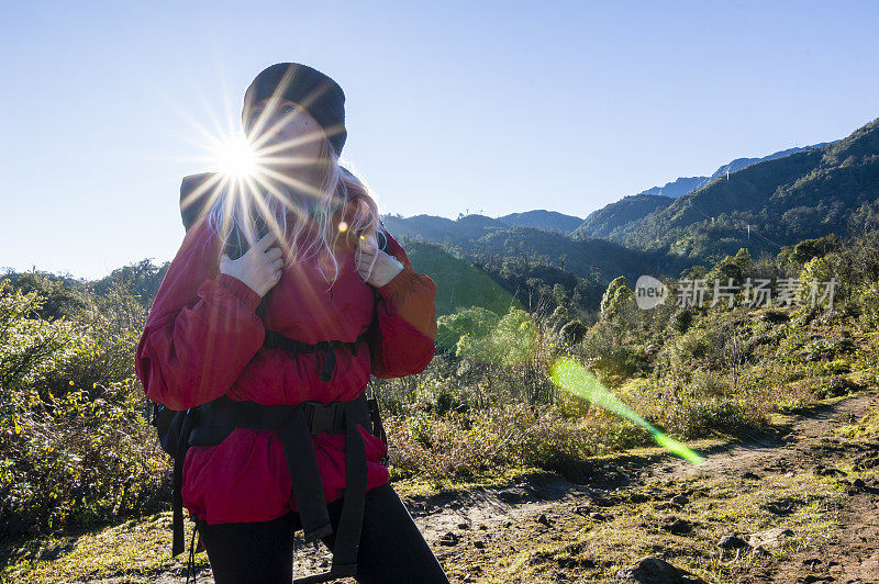 年轻女子在山间小径徒步旅行