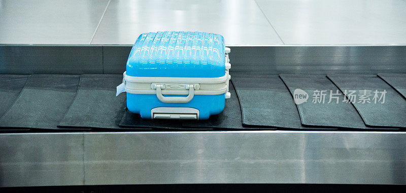 传送带上的蓝色行李箱
