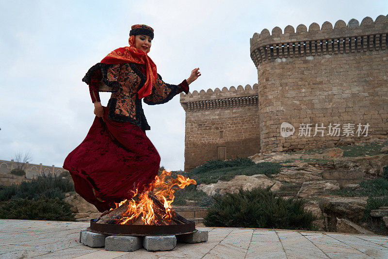 阿塞拜疆传统Novruz节日庆祝与美丽的女孩跳过火堆，