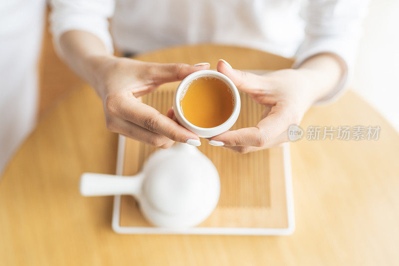 中国妇女端着一杯红茶