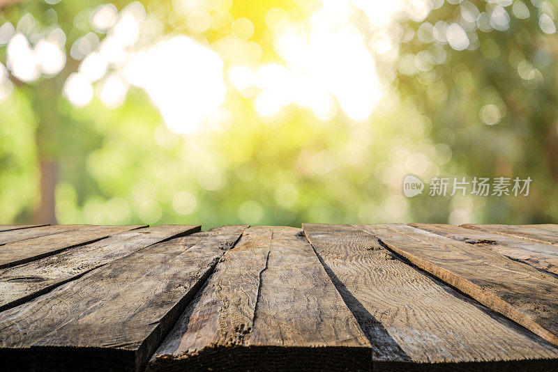 背景:空木桌与散焦黄色郁郁葱葱的树叶在背景