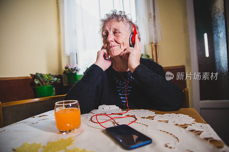 老妇人喜欢在手机上听音乐