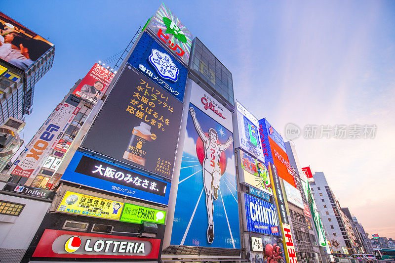 在日本大阪的道顿堀，五颜六色的广告牌照亮了大阪夜市周围的商店和零售店