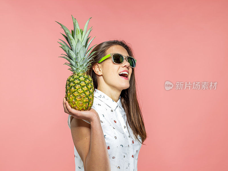 凉爽的年轻女子携带菠萝
