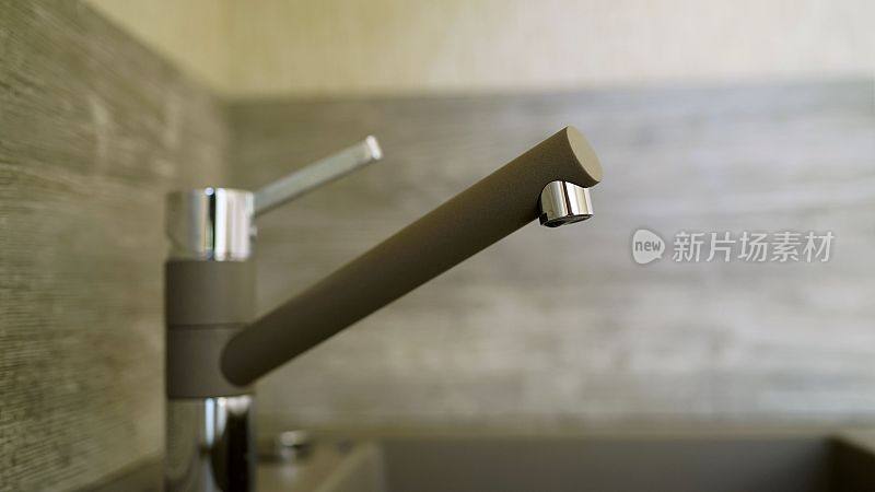 用水龙头把厨房水槽里的水打开。厨房的水龙头水槽-老式的浅色滤光片