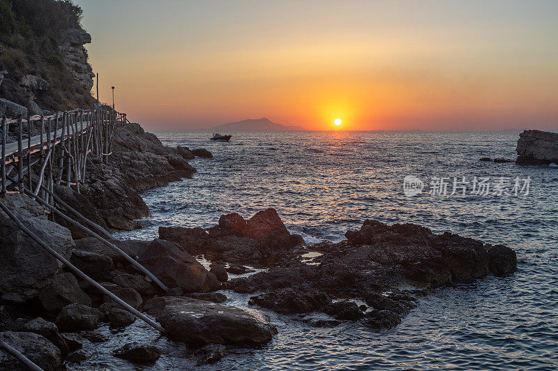 夕阳下的游船，背景是Ischia和Procida群岛