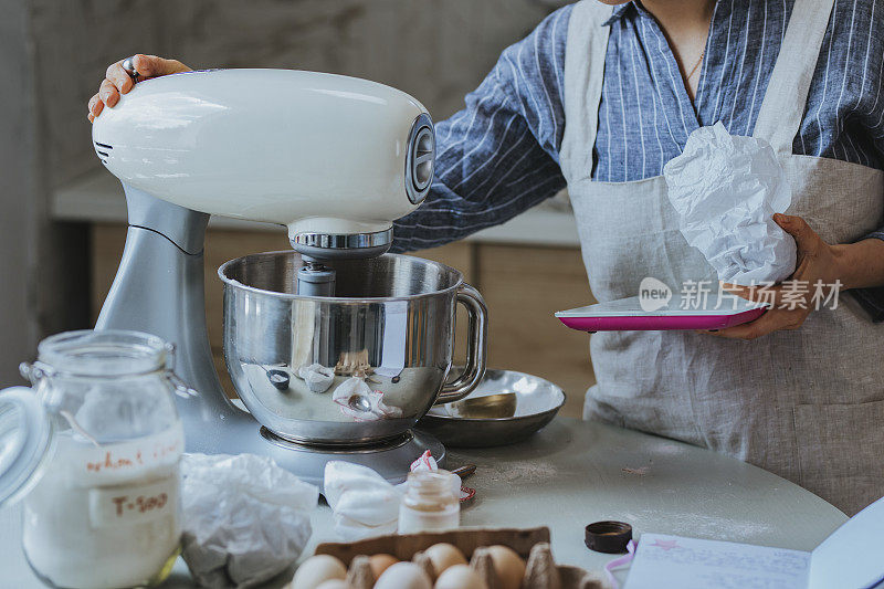 做饼干面团:一个匿名的女人在搅拌碗里搅拌配料