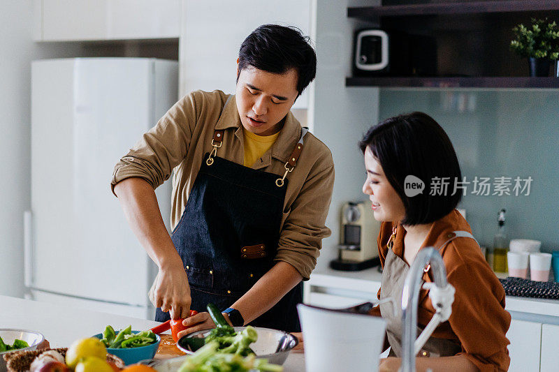 年轻的亚洲夫妇正在准备做饭的蔬菜