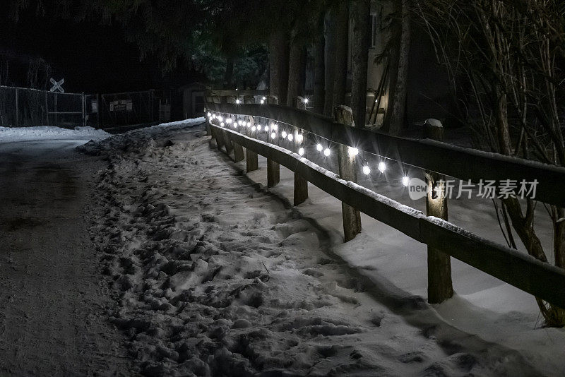 在冬天的夜晚，灯光穿过栅栏