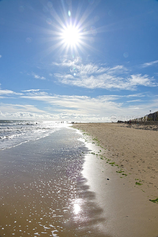 在阳光明媚的日子里，在海边和潮湿的沙滩上，面对着太阳，有着星爆效应